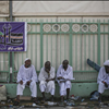 Muslim pilgrims sit by the site where pilgrims were crushed and trampled to death